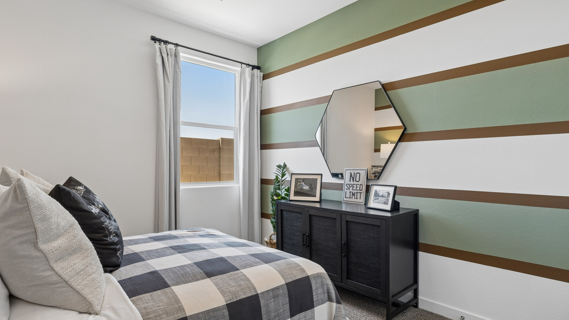 A vibrant kids' bedroom showcasing a neatly made bed, a stylish dresser, and a playful painting that adds charm.
