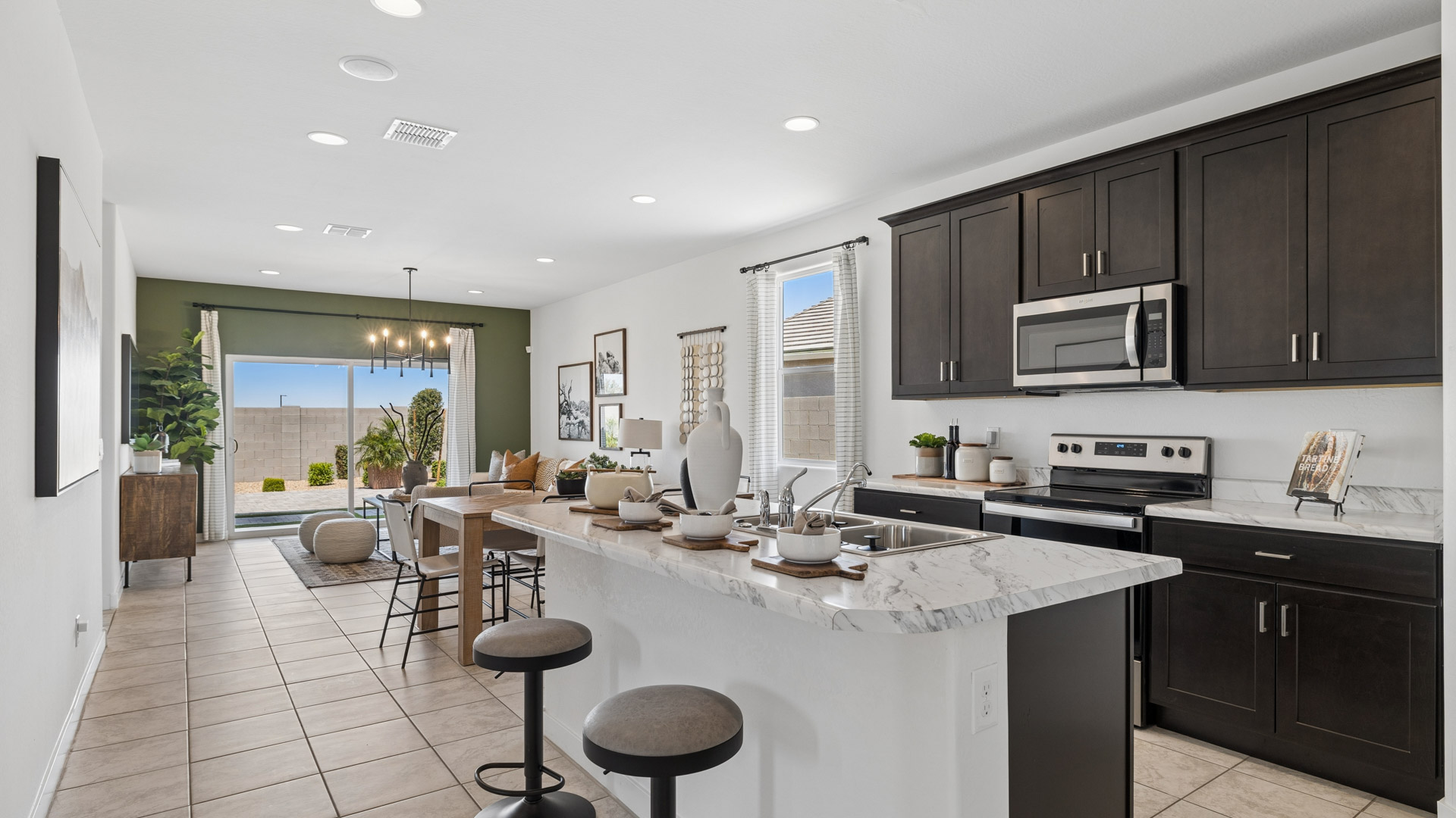 Bright and spacious kitchen with porcelain countertops, stainless steel appliances, and an island with bar seating.