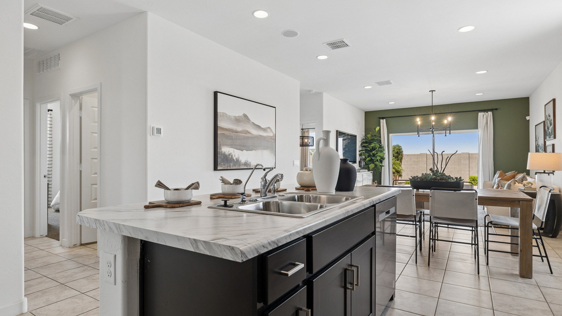 Bright and spacious kitchen with porcelain countertops, stainless steel appliances, and an island with bar seating.