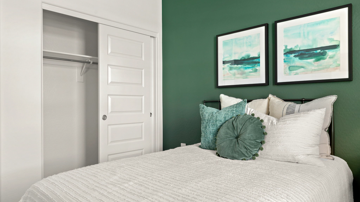 Comfortable guest bedroom featuring neutral-toned walls and a large closet.