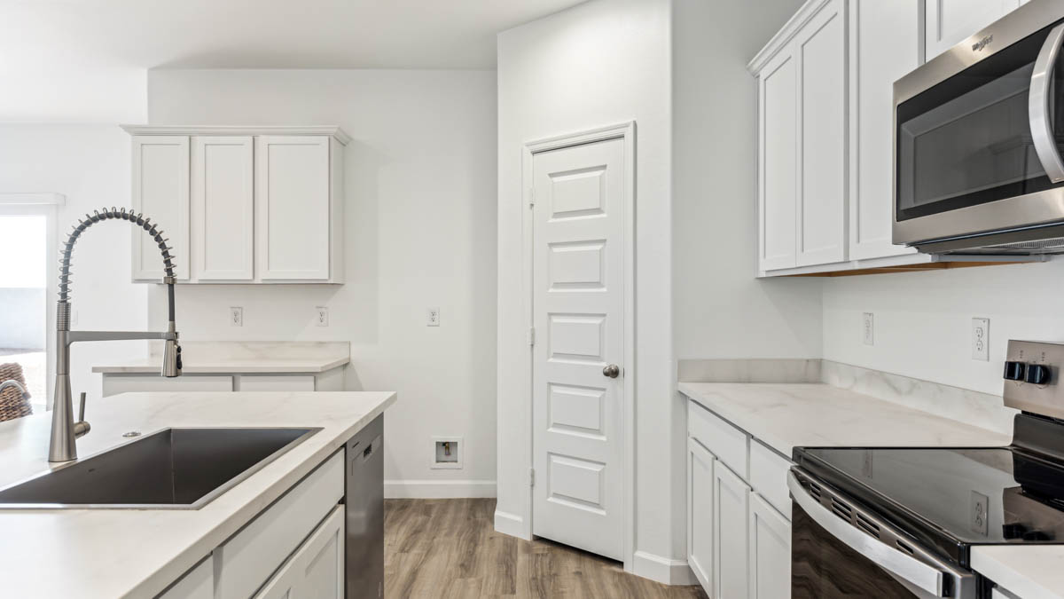 Bright and spacious kitchen with porcelain countertops, stainless steel appliances, and an island with bar seating.