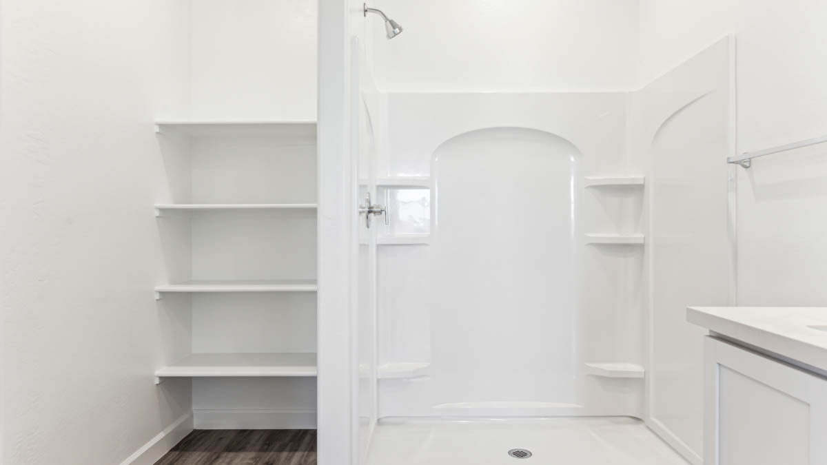 Modern primary bathroom with double vanities, quartz countertops with a walk-in shower and a walk-in closet.