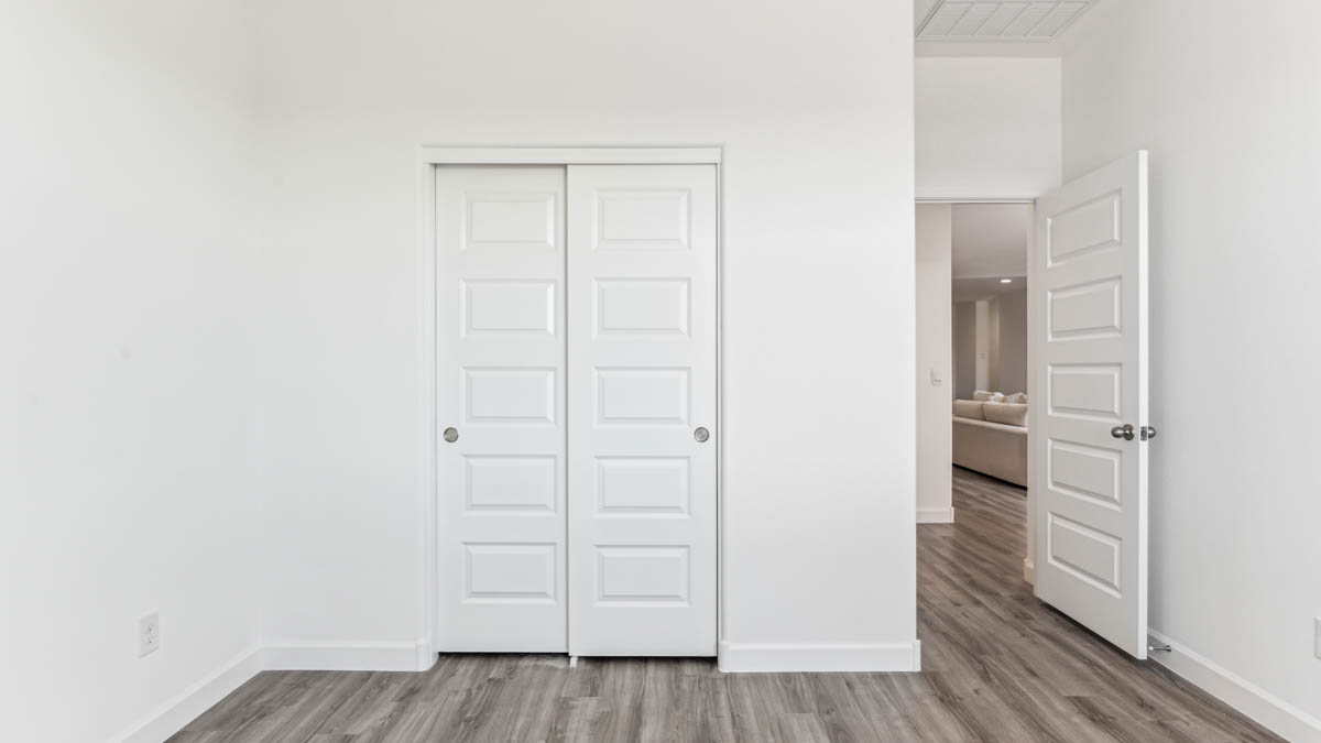 Comfortable guest bedroom featuring neutral-toned walls and a large closet.