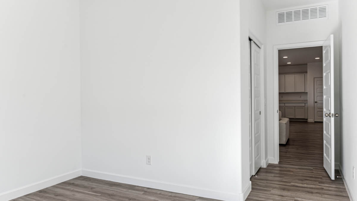 Comfortable guest bedroom featuring neutral-toned walls and a large closet.