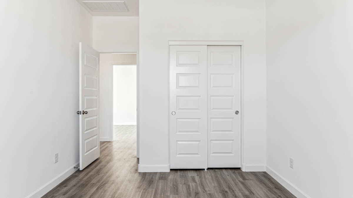 Comfortable guest bedroom featuring neutral-toned walls and a large closet.