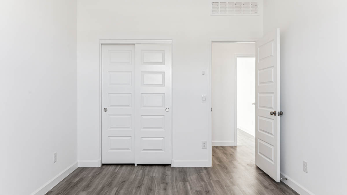 Comfortable guest bedroom featuring neutral-toned walls and a large closet.