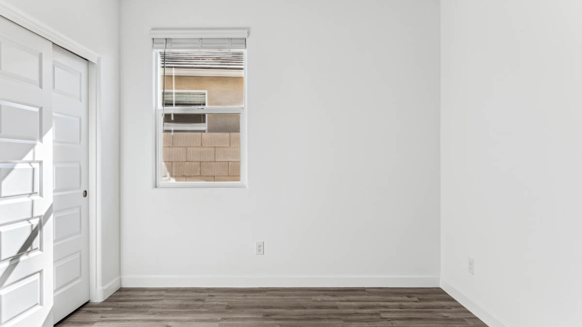 Comfortable guest bedroom featuring neutral-toned walls and a large closet.