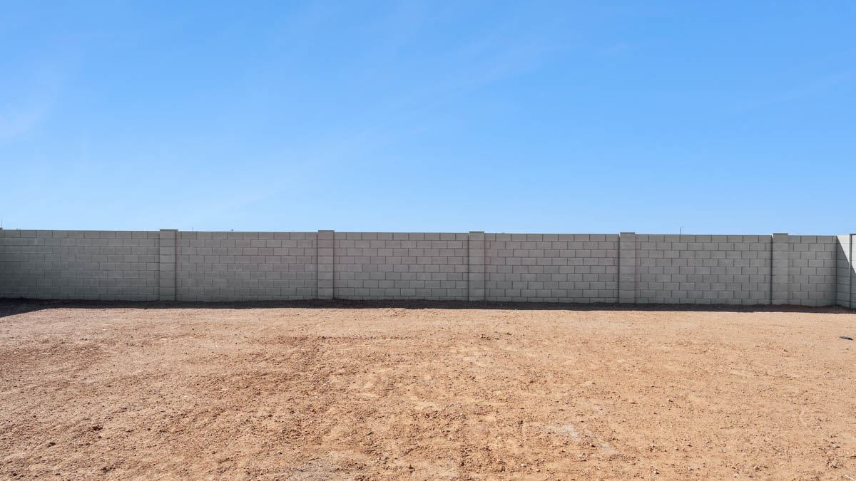 Large fenced-in backyard with a covered patio, perfect for outdoor entertaining.