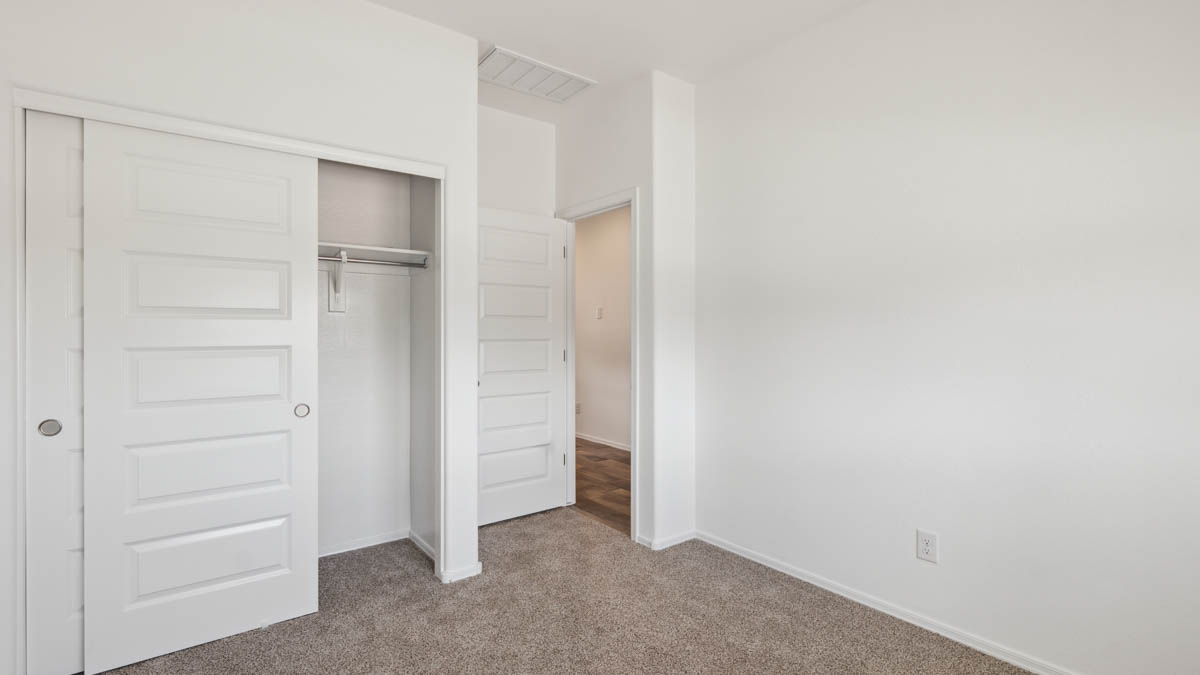 Comfortable guest bedroom featuring neutral-toned walls and a large closet.