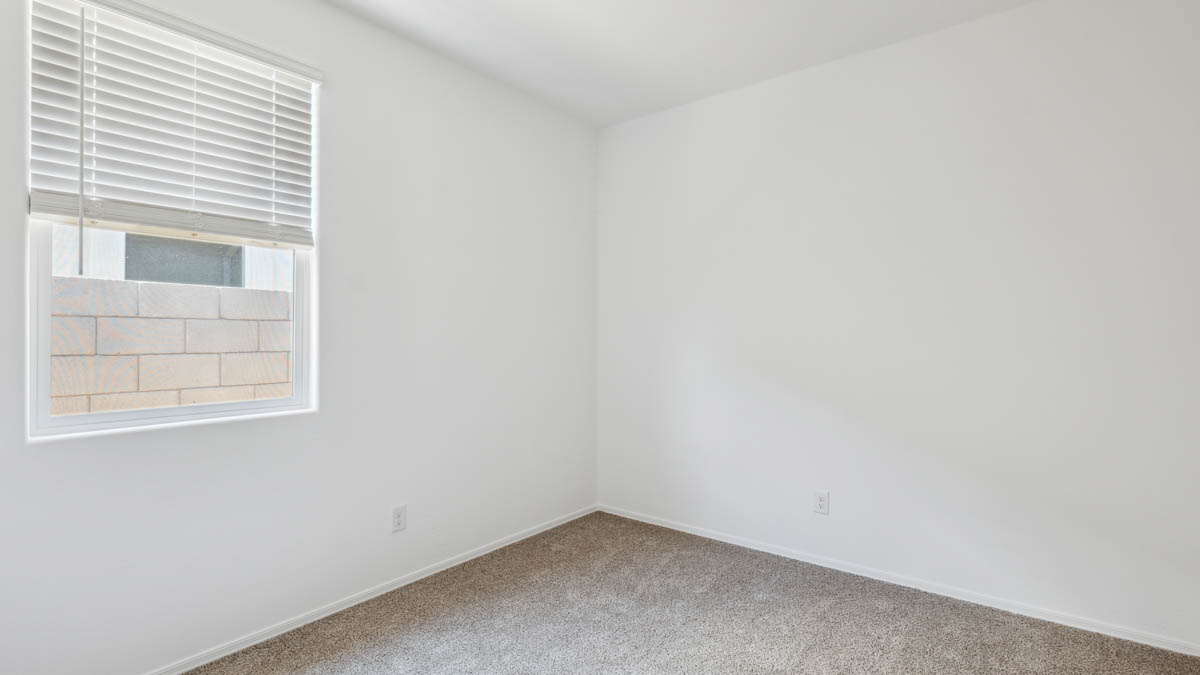 Comfortable guest bedroom featuring neutral-toned walls and a large closet.