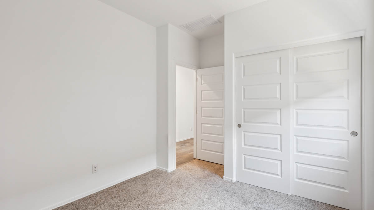 Comfortable guest bedroom featuring neutral-toned walls and a large closet.