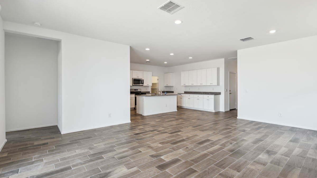 A well-organized living room that includes a kitchen and dining area, creating a warm and welcoming environment for gatherings.