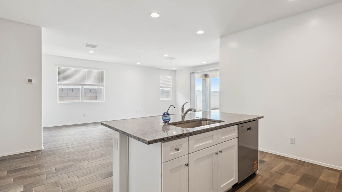 Bright and spacious kitchen with granite countertops, stainless steel appliances, and an island with bar seating.