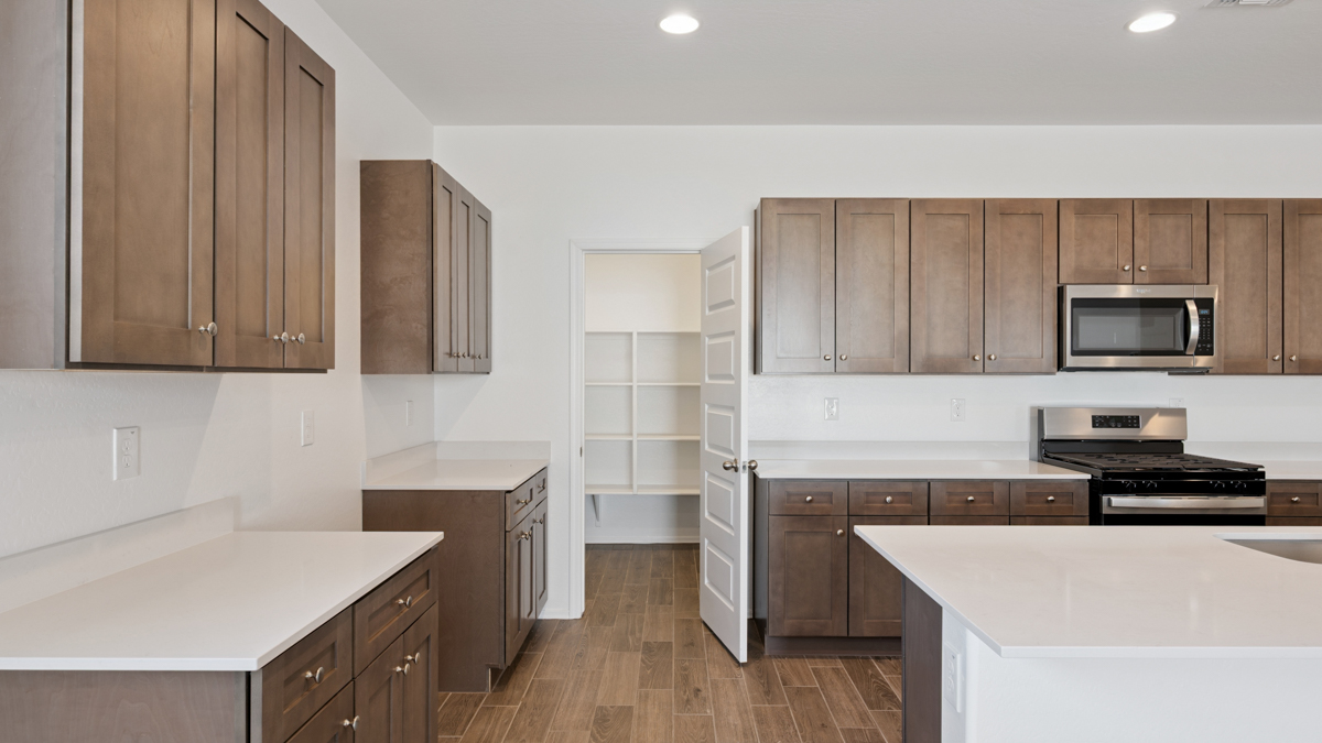 Bright and spacious kitchen with quartz countertops, stainless steel appliances, and an island with bar seating.