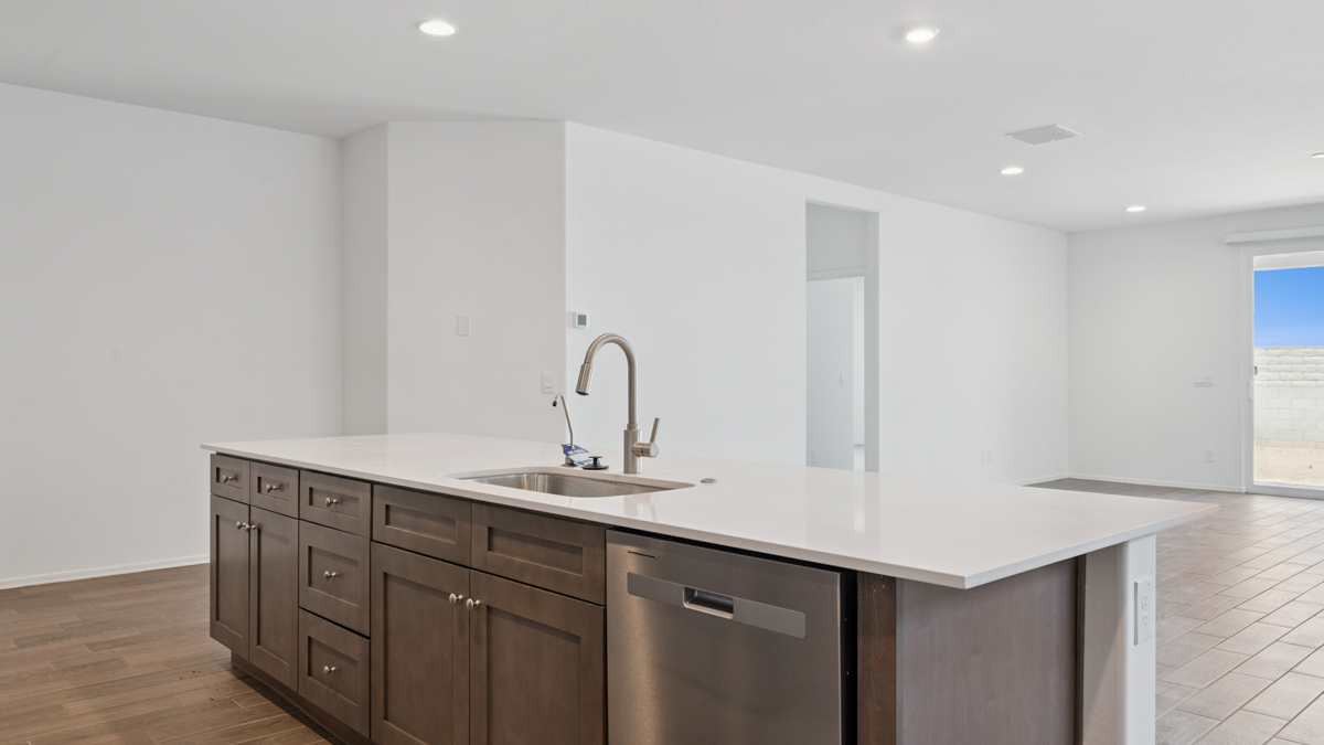 Bright and spacious kitchen with quartz countertops, stainless steel appliances, and an island with bar seating.