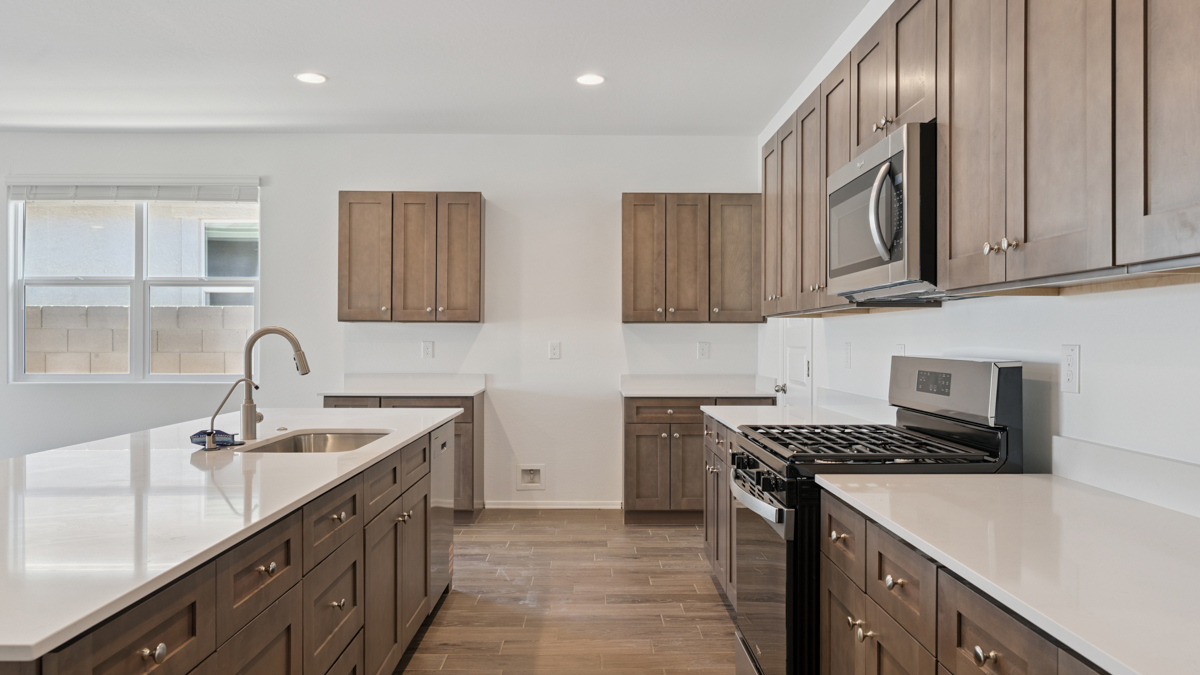 Bright and spacious kitchen with quartz countertops, stainless steel appliances, and an island with bar seating.