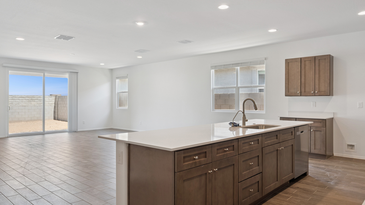 Bright and spacious kitchen with quartz countertops, stainless steel appliances, and an island with bar seating.