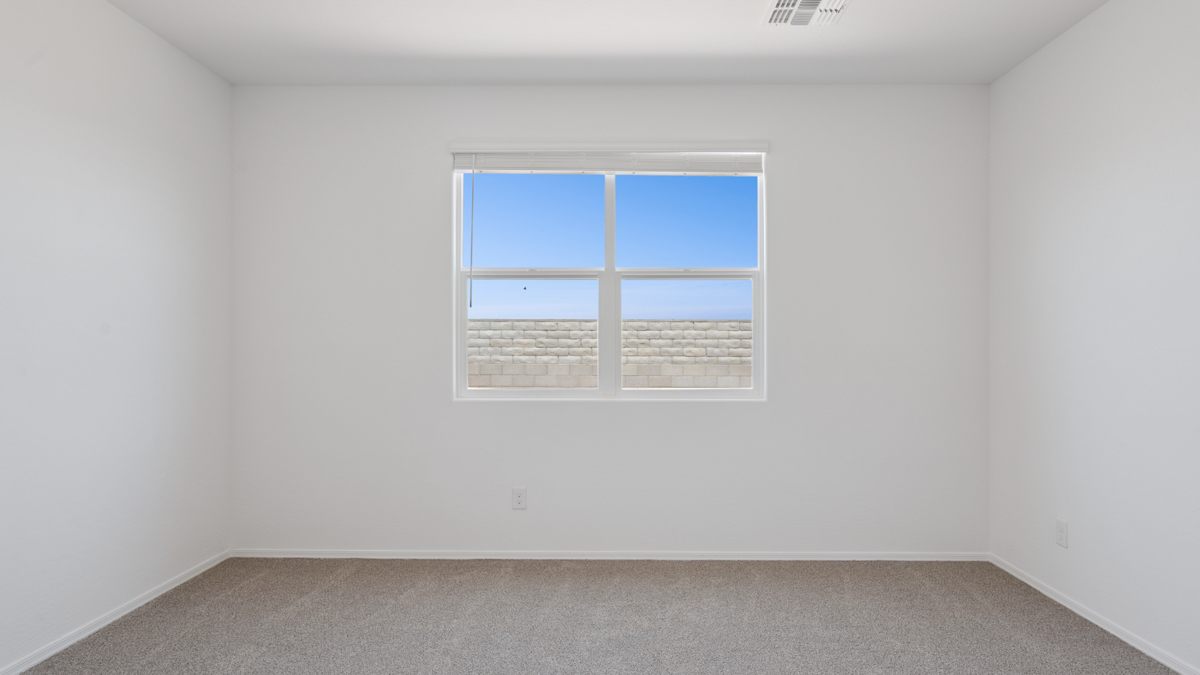 A spacious primary bedroom emphasizing open space and natural lighting.