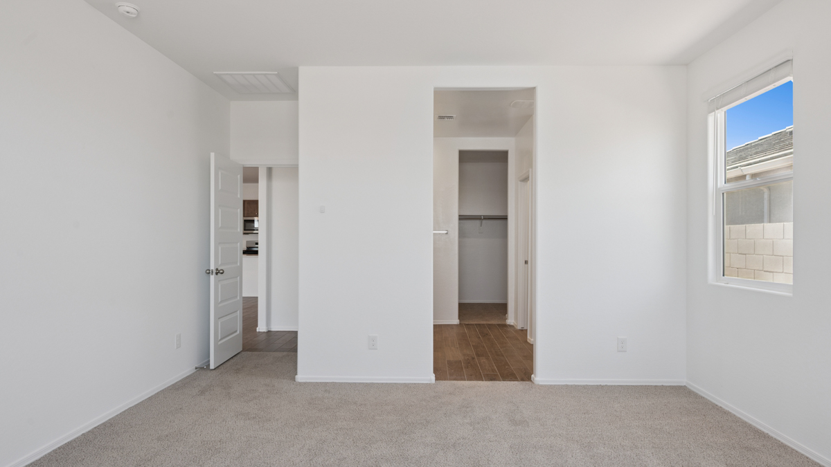 A spacious primary bedroom emphasizing open space and natural lighting.