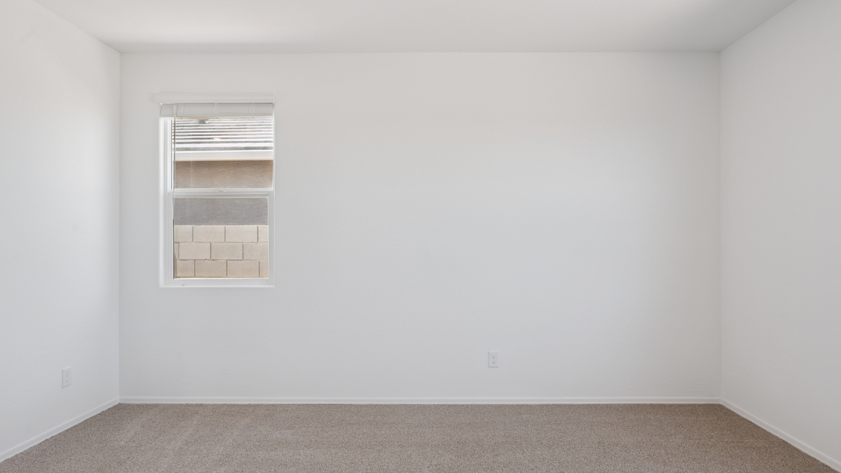 A spacious primary bedroom emphasizing open space and natural lighting.