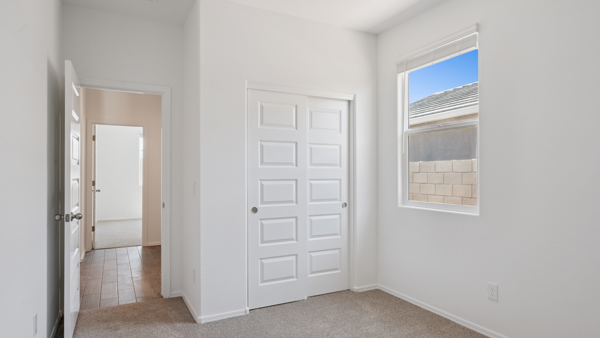 Comfortable guest bedroom featuring neutral-toned walls and a large closet.