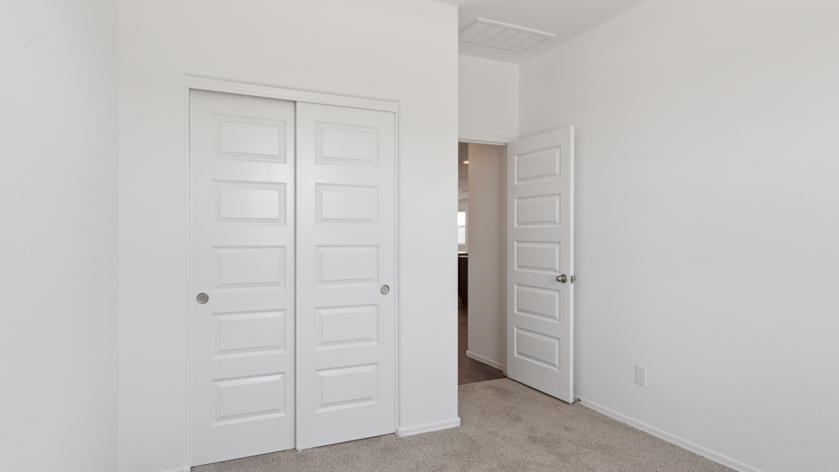 Comfortable guest bedroom featuring neutral-toned walls and a large closet.