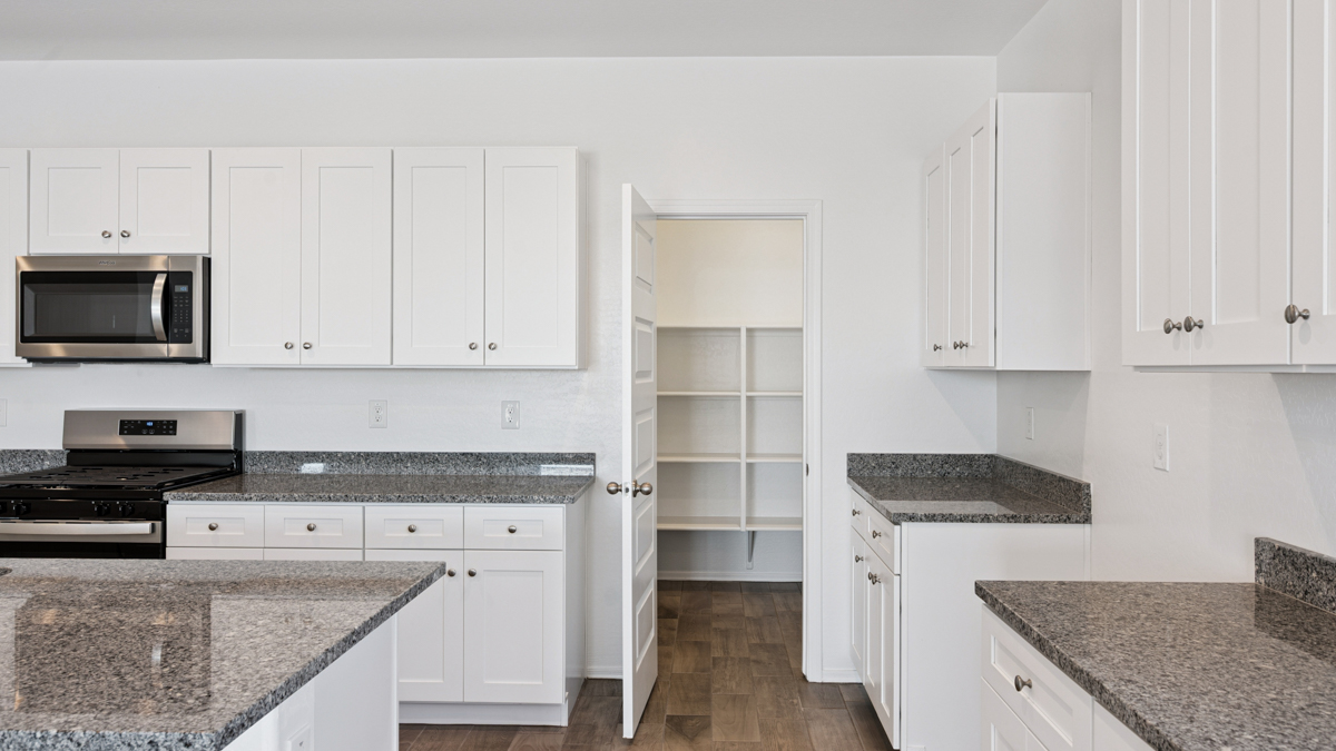 Bright and spacious kitchen with granite countertops, stainless steel appliances, and an island with bar seating.