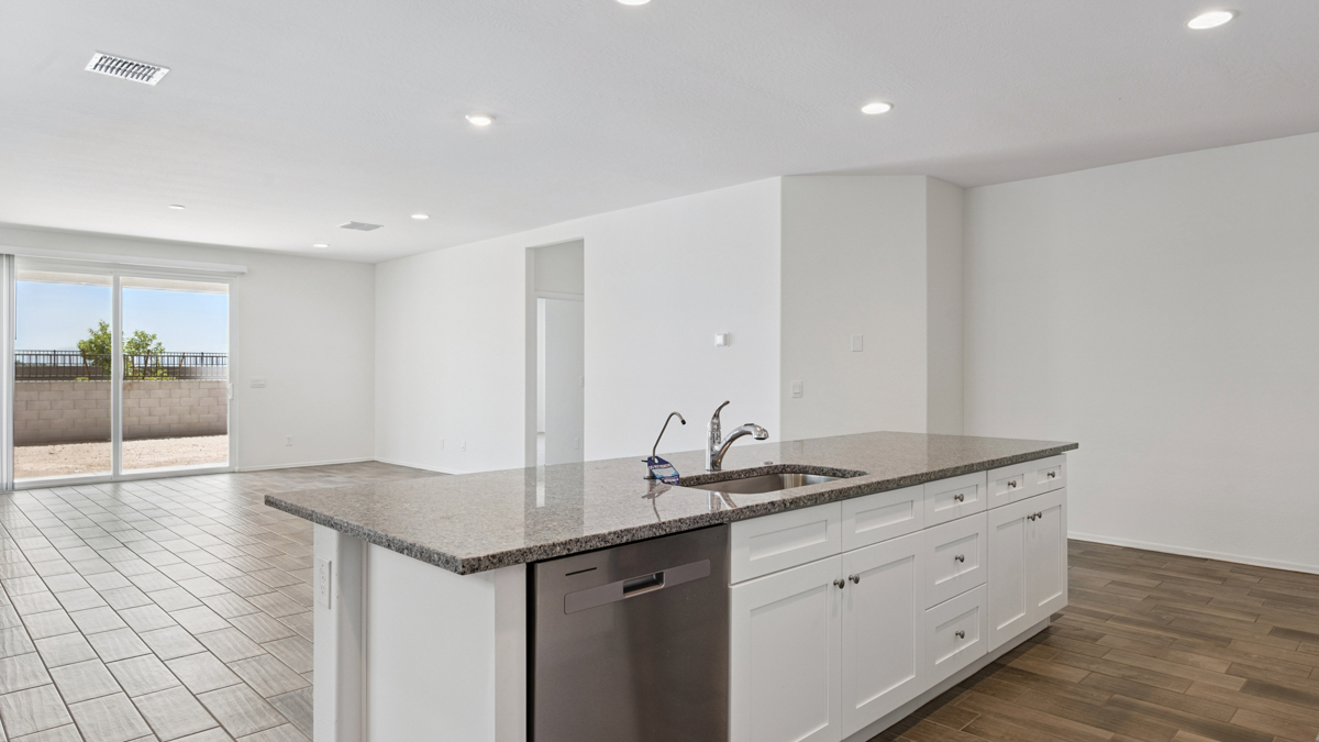 Bright and spacious kitchen with granite countertops, stainless steel appliances, and an island with bar seating.