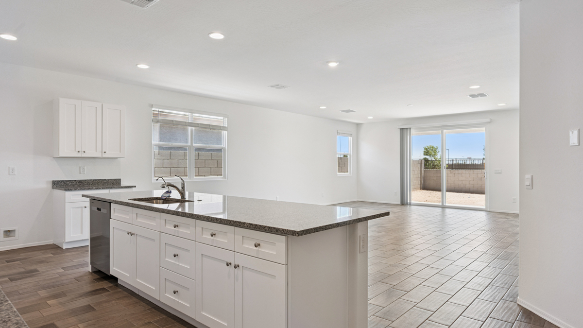 Bright and spacious kitchen with granite countertops, stainless steel appliances, and an island with bar seating.