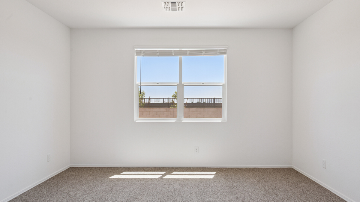 A spacious primary bedroom emphasizing open space and natural lighting.