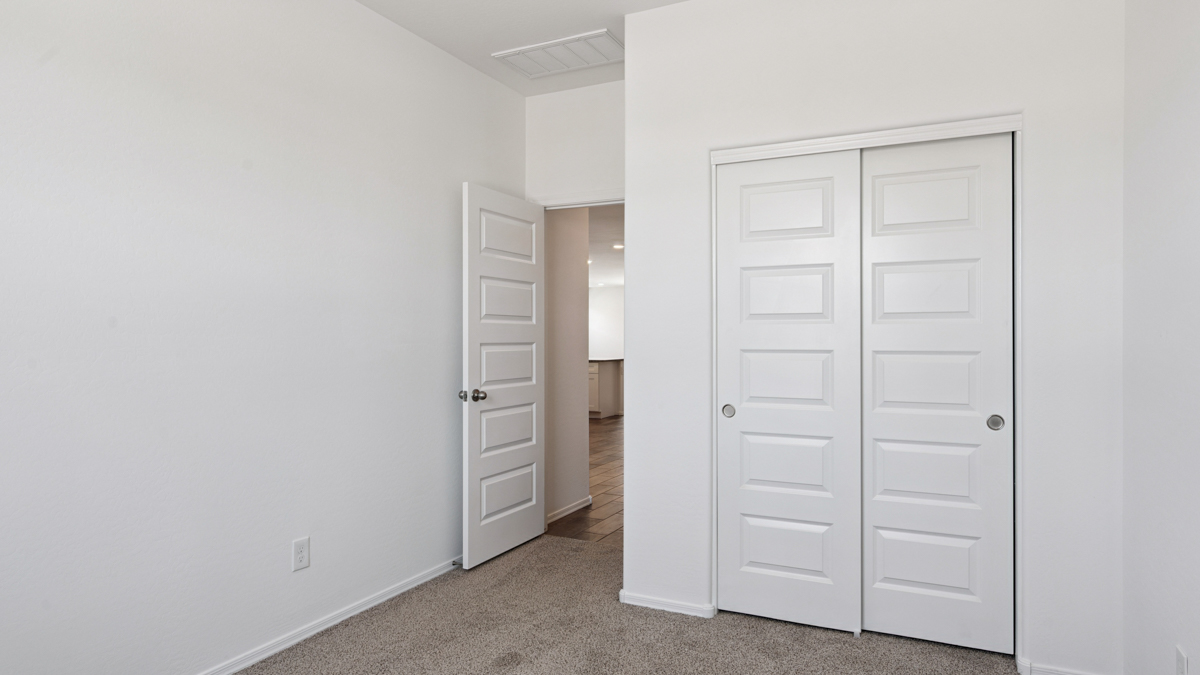 Comfortable guest bedroom featuring neutral-toned walls and a large closet.