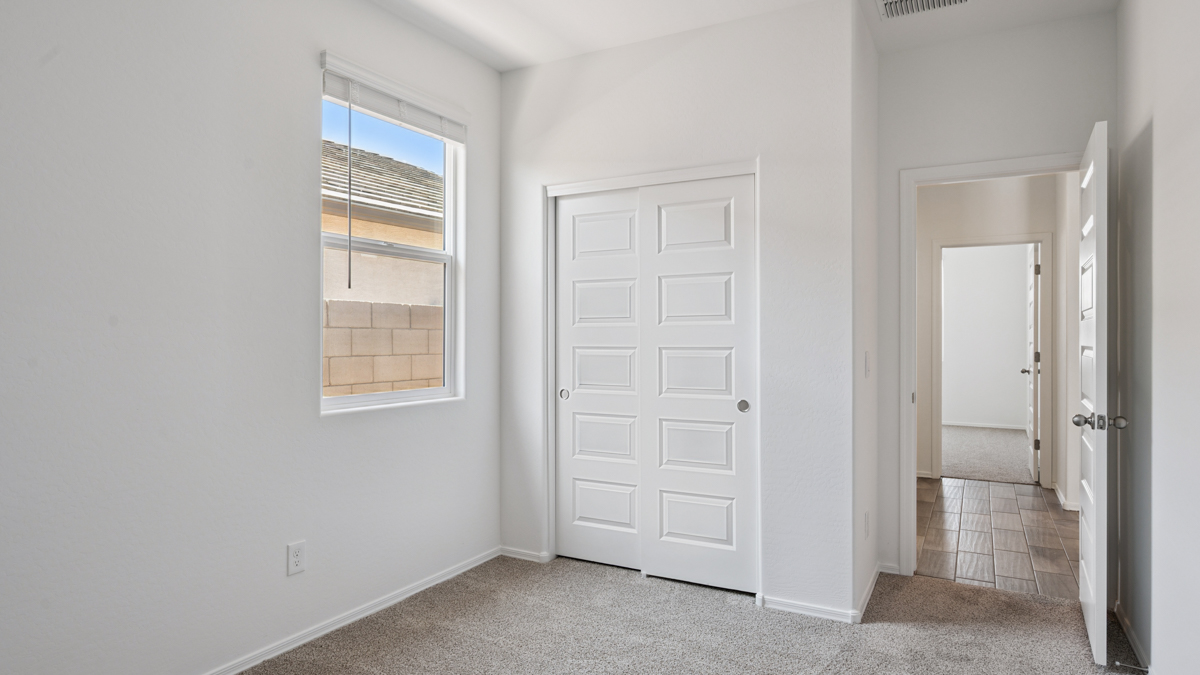 Comfortable guest bedroom featuring neutral-toned walls and a large closet.