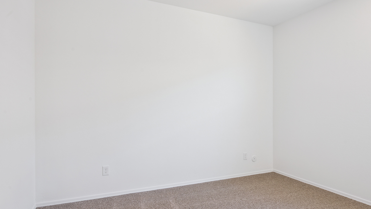 Comfortable guest bedroom featuring neutral-toned walls and a large closet.