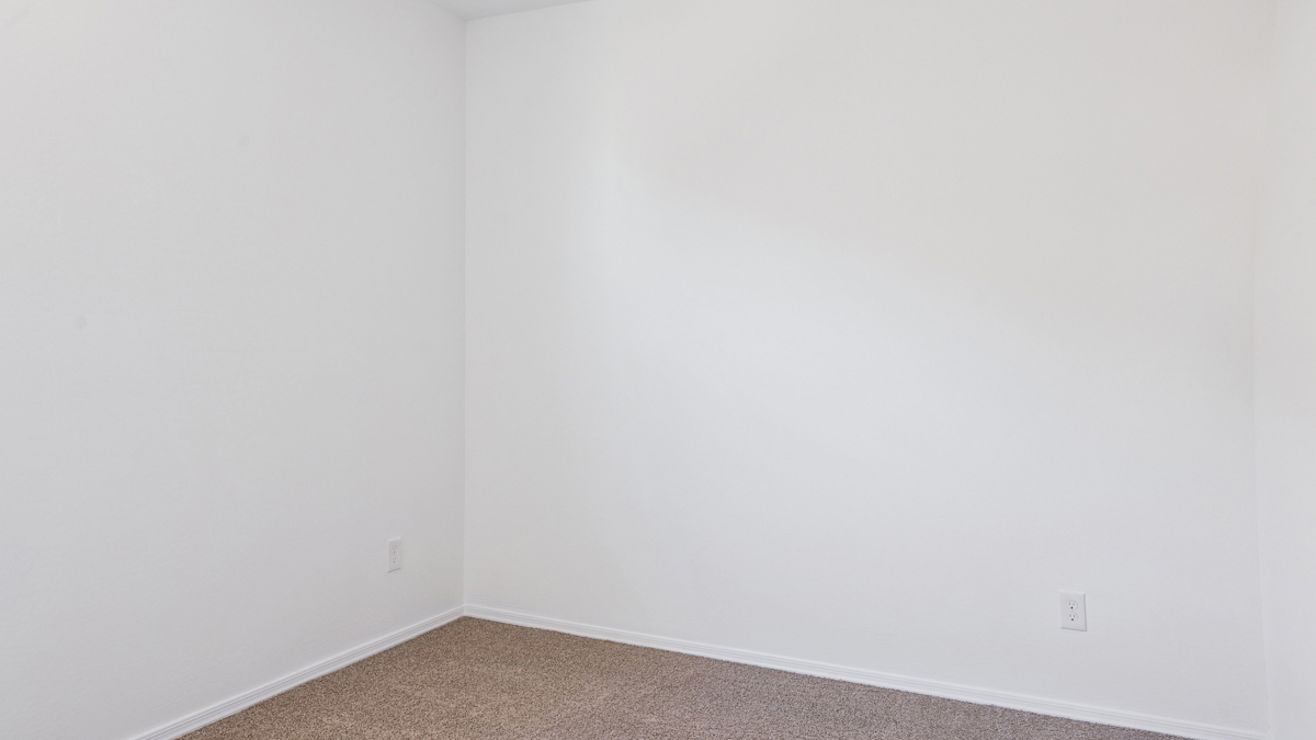 Comfortable guest bedroom featuring neutral-toned walls and a large closet.