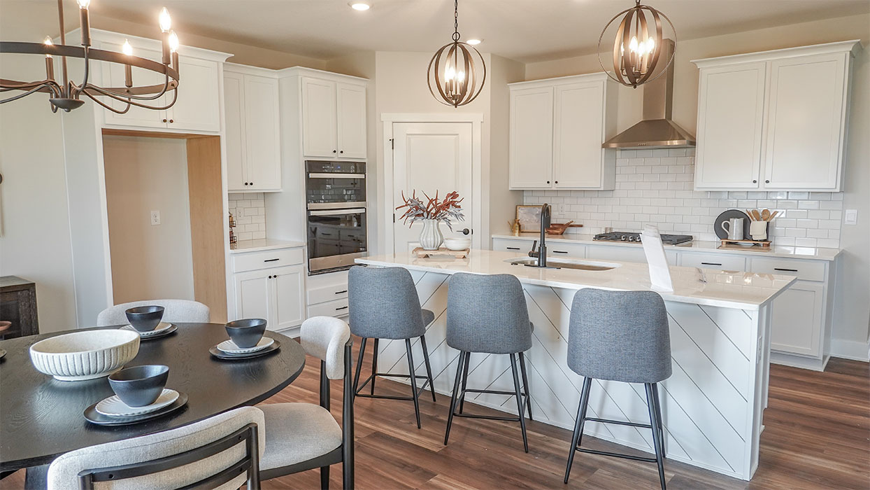 Kitchen with stainless steel appliances, quartz countertops, and white cabinetry