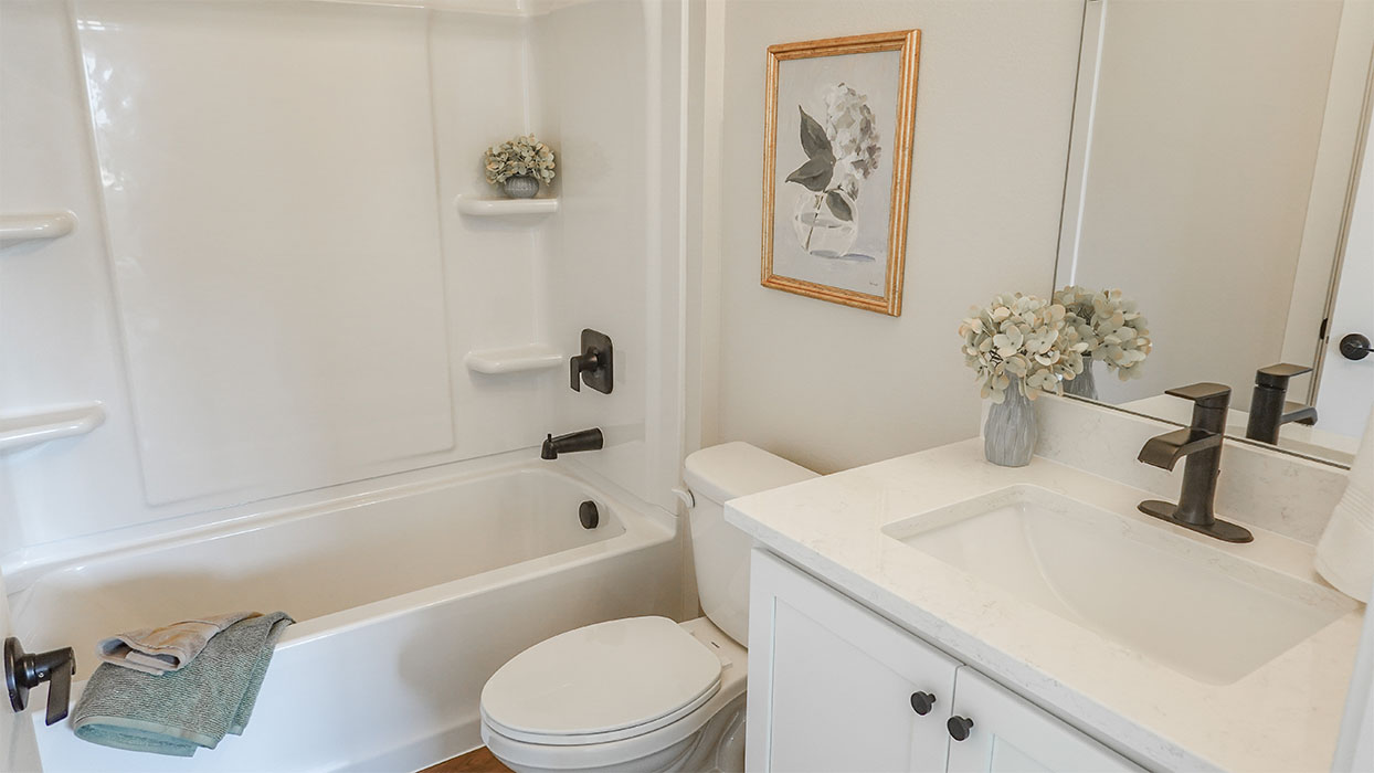 Bathroom with tub and shower combo, quartz countertops, and white vanity