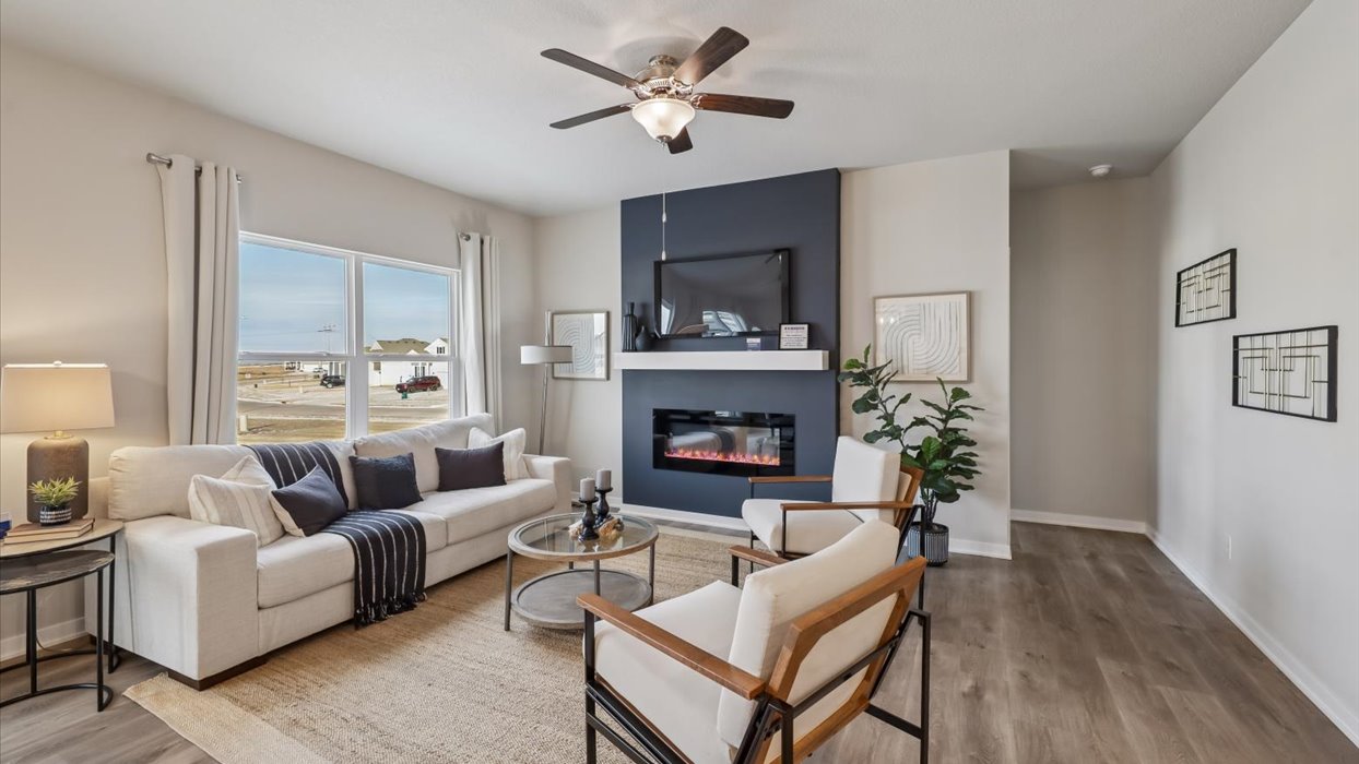 roland living room with ceiling fan and accent wall