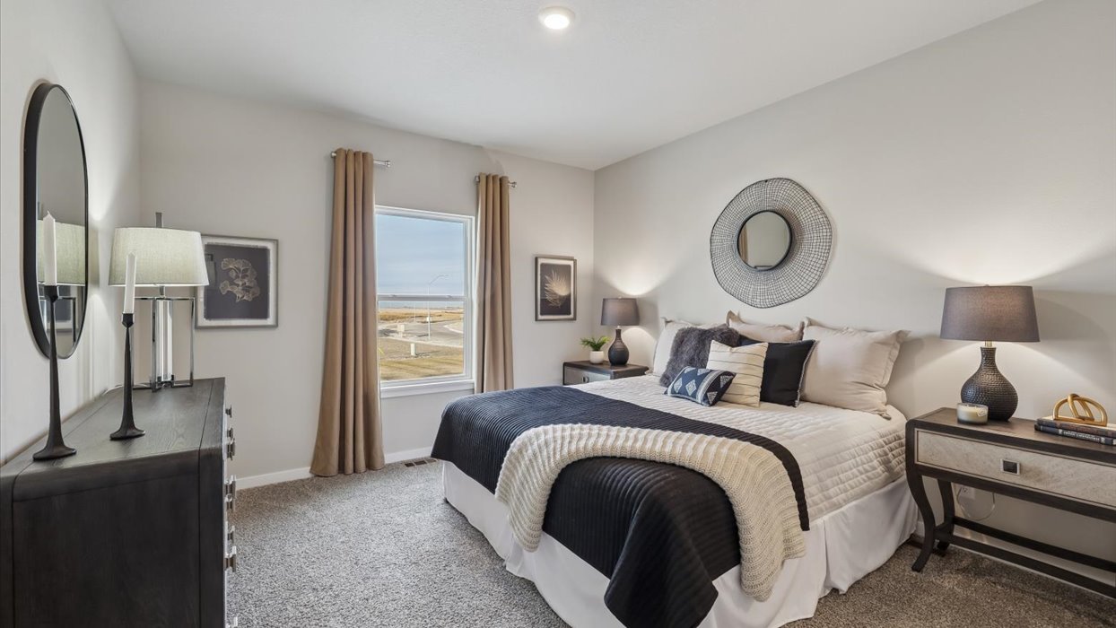 primary bedroom with window and cozy furniture