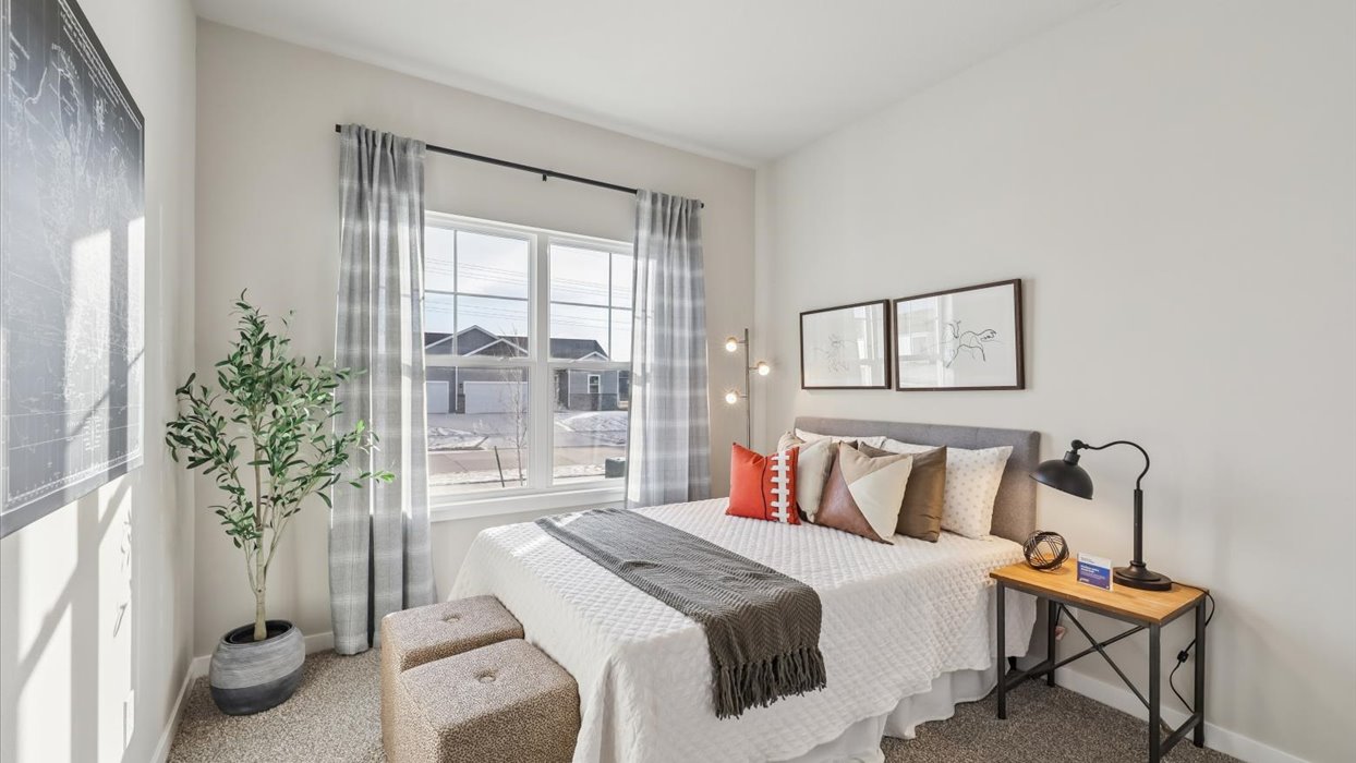 first bedroom with large window and white bed