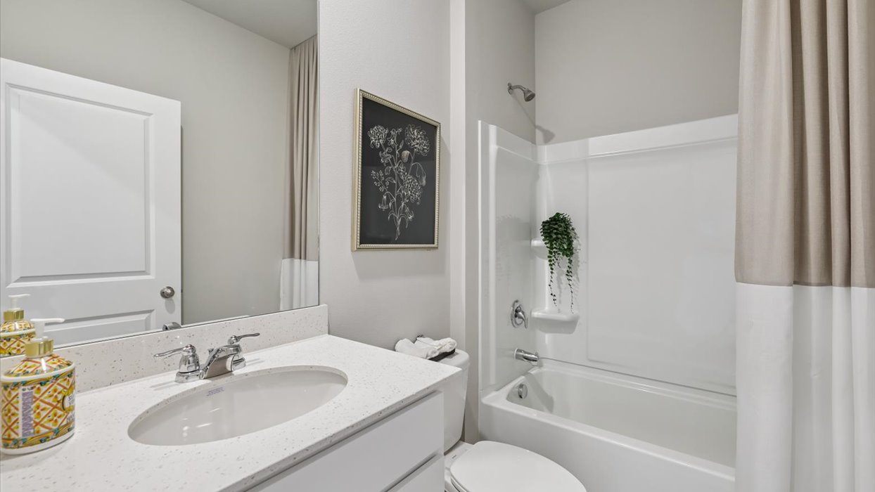 first bathroom with mirror and shower and bathtub