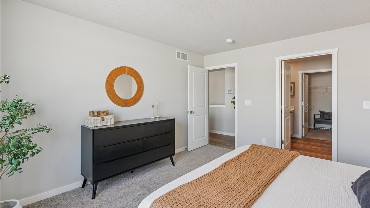 primary bedroom with bed and black dresser