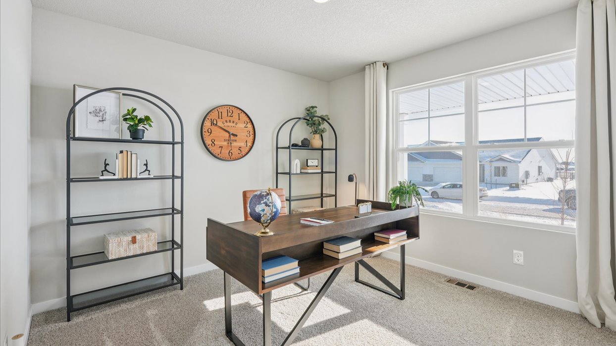 second bedroom staged as an office with desk and bookstand