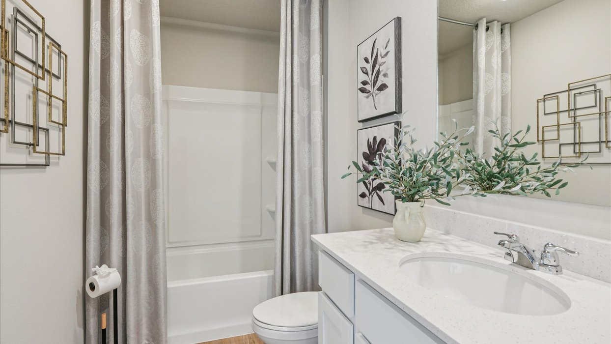 first bathroom with large mirror and walk-in shower