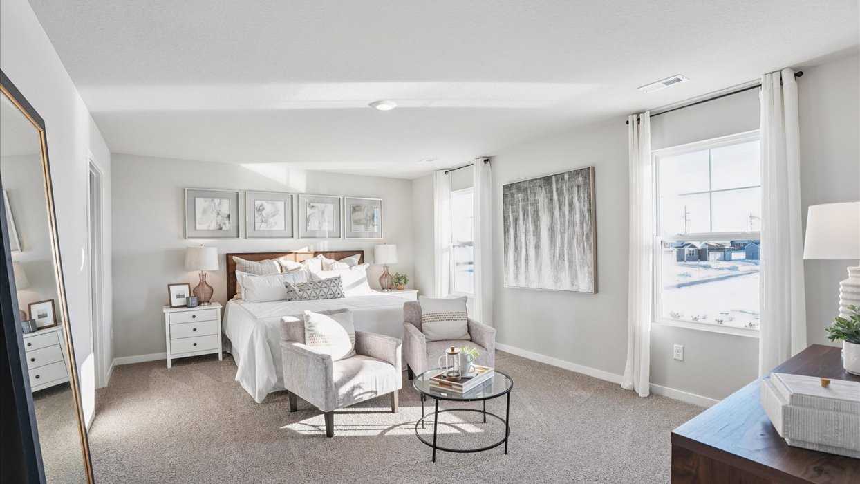 spacious primary bedroom with two small windows