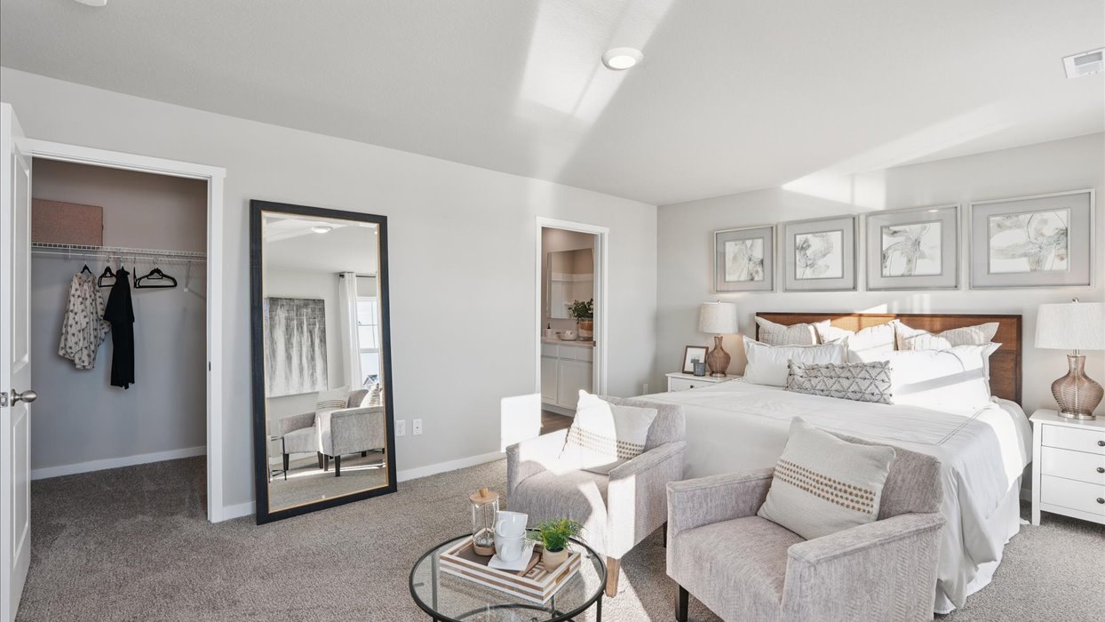 primary bedroom with white bed and view of closet