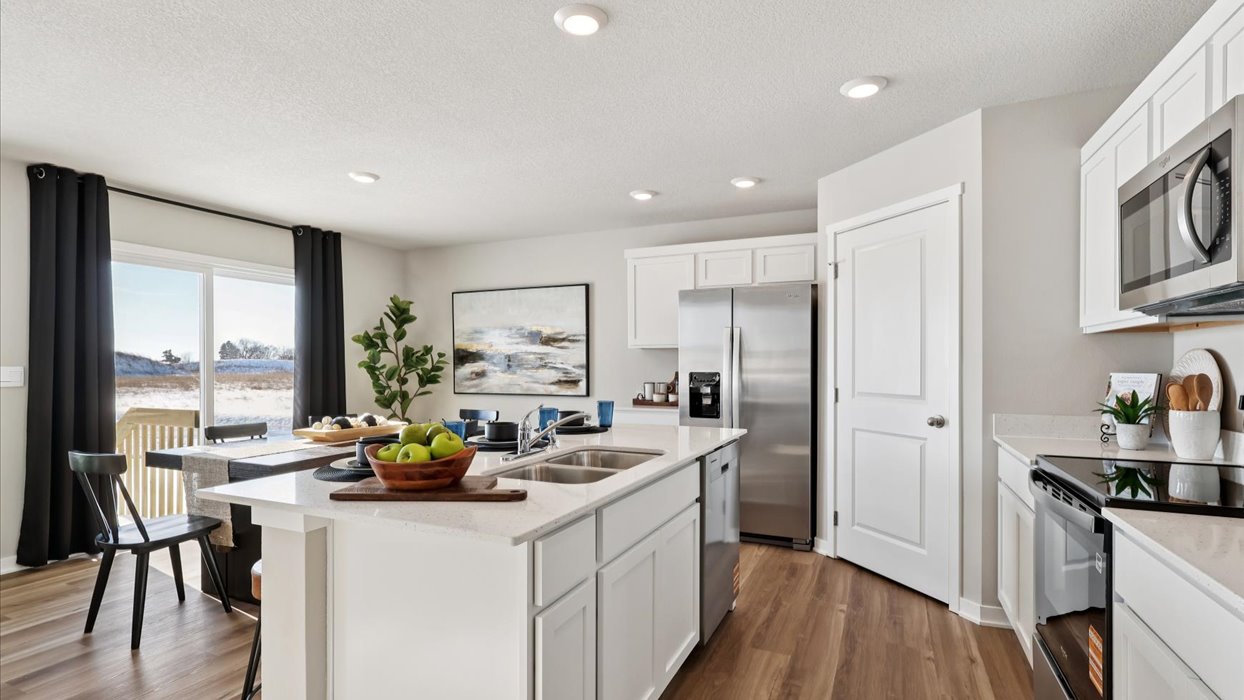 Kitchen with stainless steel appliances, quartz countertops, and white cabinetry