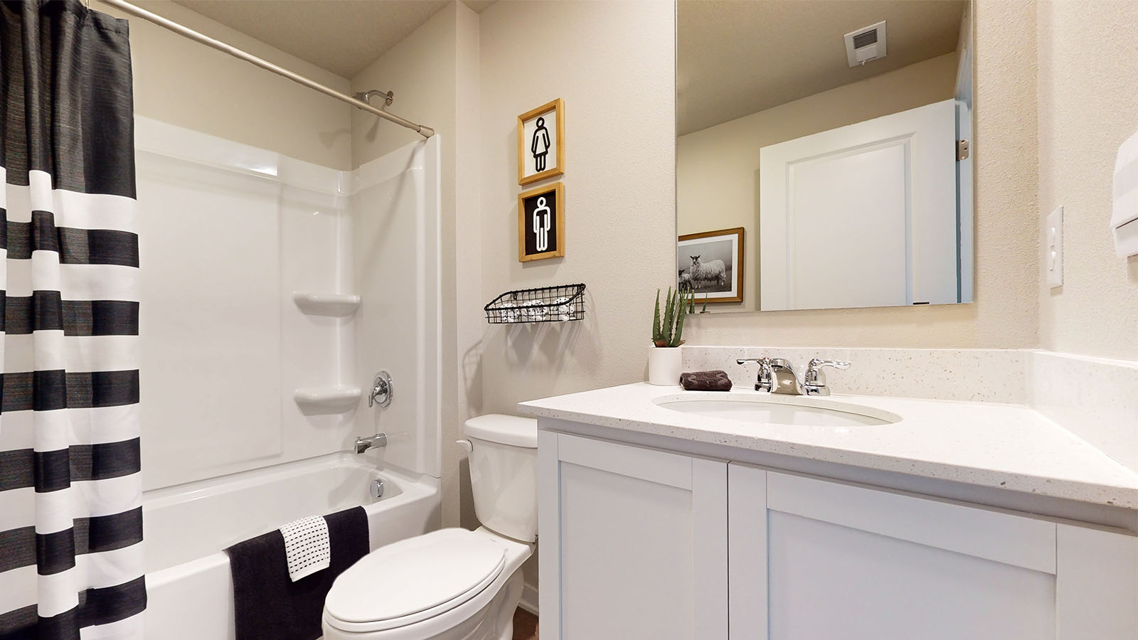 Second bathroom in basement with white cabinetry