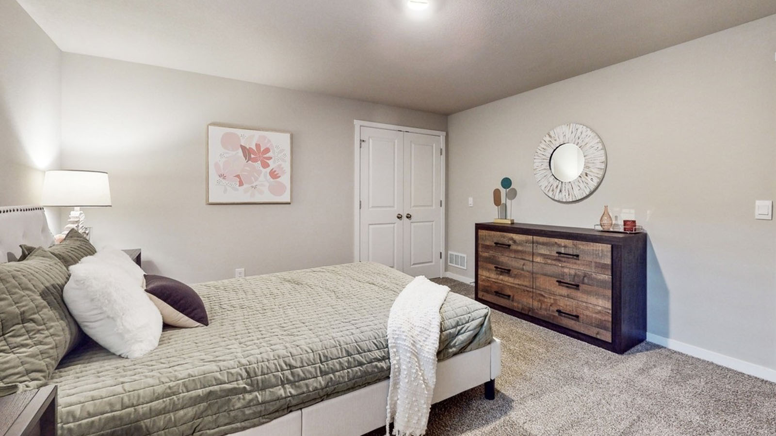 Private lower-level bedroom with natural light and functional storage space.