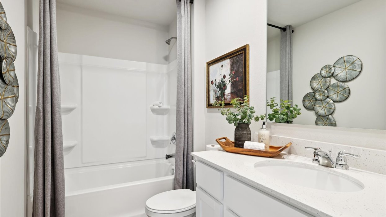 first bathroom with large mirror and shower with bathtub