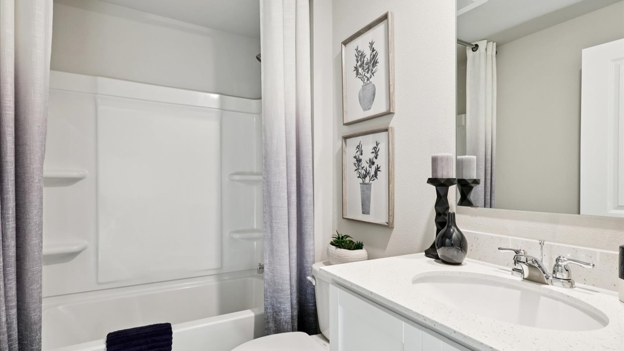 second bathroom with mirror and quartz countertops